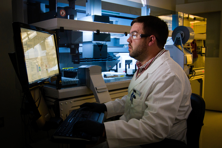 adisco apuania odv terzo corso formativo: ricercatore scientifico in camice bianco ed occhiali lavora al computer nel laboratorio di un istituto di ricerca sulle cellule staminali emopoietiche